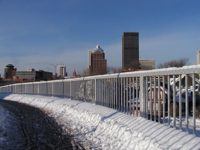 Photo Rochester New York skyline rides a snow covered rail. From left, First Federal, Blue Cross and Blue Shield, Hyatt Hotel, St. Mary's Chruch Steeple, Lincoln Tower behind Bausch and Lomb, Xerox Tower, Midtown Plaza, and HSBC Bank on right edge of photo. Rochester NY New York City living January 31st 2003 POD I Love NY Rochester NY New York winter Picture Of The Day view picture photo image picture pictures photos images, January 31st 2003 POD