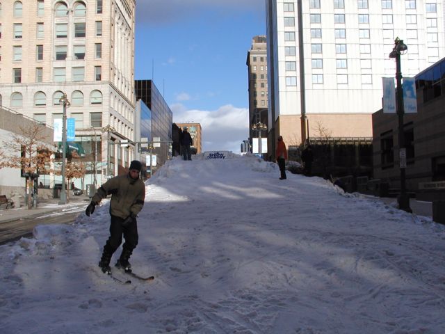 Picture A skier completes an exhilarating run down East Main st. Rochester NY New York as part of the Coldrush Festival. View looking East on East Main Street at the intersection where Saint Paul St. Becomes South Ave.  February 8th 2003 POD winter Picture Of The Day view picture photo image picture pictures photos images, February 8th 2003 POD