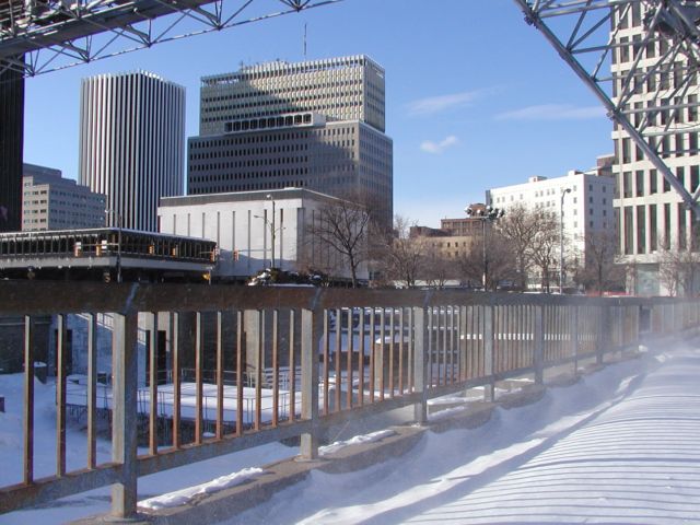 Picture Wind whipped snow blows through safety rails to take center stage at Manhattan Square Park. A bit of Xerox, B&L, Lincoln Tower, Midtown Plaza, Cadilac Hotel, HSBC, visible. Rochester NY February 17th 2003 POD winter Picture Of The Day view picture photo image picture pictures photos images