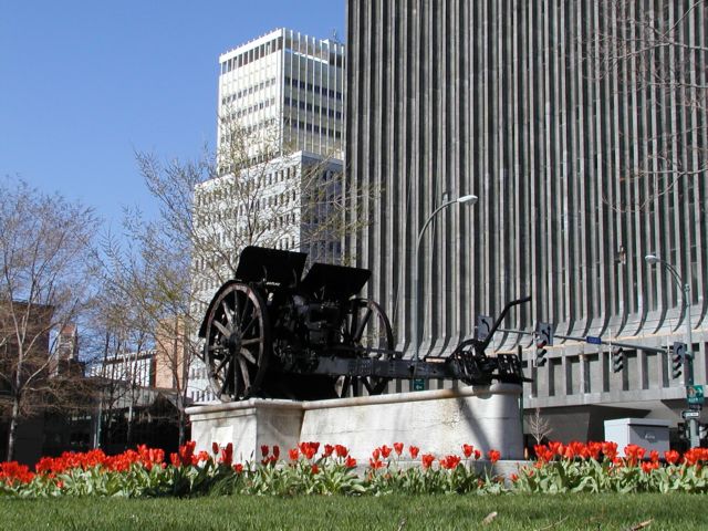 Picture Spring Tulips surround The Austrian Cannon monument at Washington Square Park, looking north. The plaque on the base of the monument reads that the cannon was 'captured by the undefeated third Italian Army in the Battle of Vittorio Veneto, October 24 - November 3, 1918 . . the first decisive victory of the Allies'. The cannon was a gift 'to the patriotic city of Rochester' in June 1921, from the Italian government.  cannon located in Washington Square Park, downtown Rochester NY. Midtown plaza, and Xerox are to the right. Rochester New York Picture Of The Day from DigitalSter.Com & RocPic.Com winter spring summer fall pictures photos images people buildings events concerts festivals photo image at digitalster.com new images daily 2003 Rochester NY New York