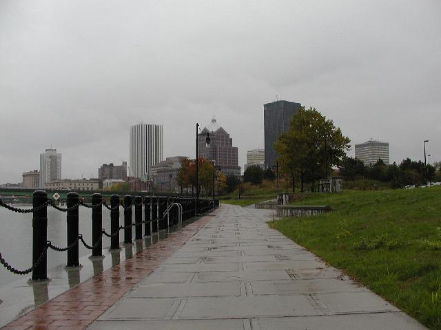 Rochester NY New York Pictures Walk In Rain On Sidewalk Along East Bank Of Genesee River Holiday Inn Hyatt Lincoln Tower Bausch & Lomb Xerox Midtown Plaza HSBC Buildings In View Fall October 2002 Rochester NY New York Photo Todays Picture of Rochester NY New York Photos Pictures Image Images