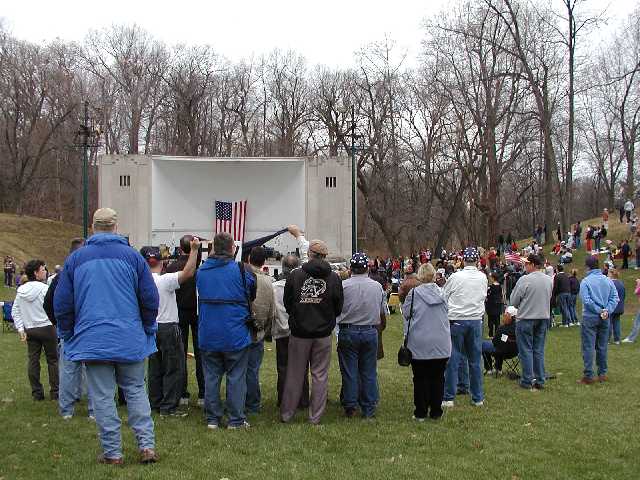 A very solid crowd of America supporters deploys their own version of defensive shields to spare those on stage from the site of a protester. Image 41 of 60  -  58 kB